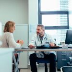 Médico atienda a una paciente | Dreamstime