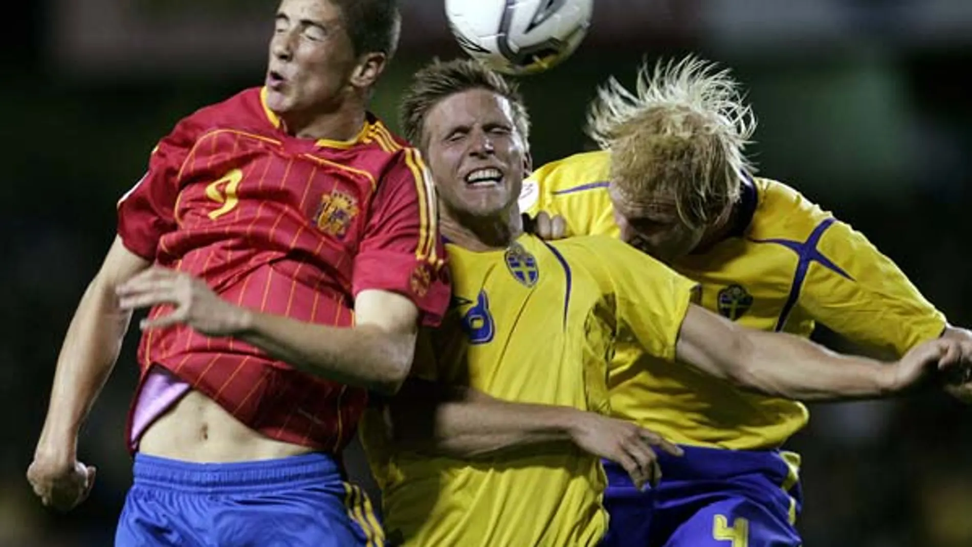 Fernando Torres pelea un balón con dos jugadores suecos.