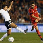 El centrocampista del Valencia Javi Fuego disputa un balón con el centrocampista del Olympique de Lyon Maxime Gonalons