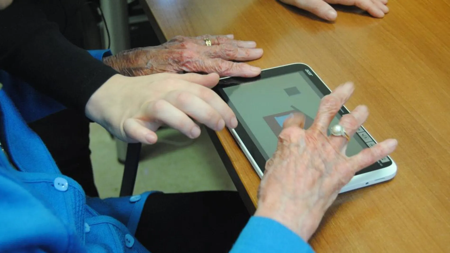 Una mujer interactúa con una tablet en un programa de La Caixa para frenar la demencia