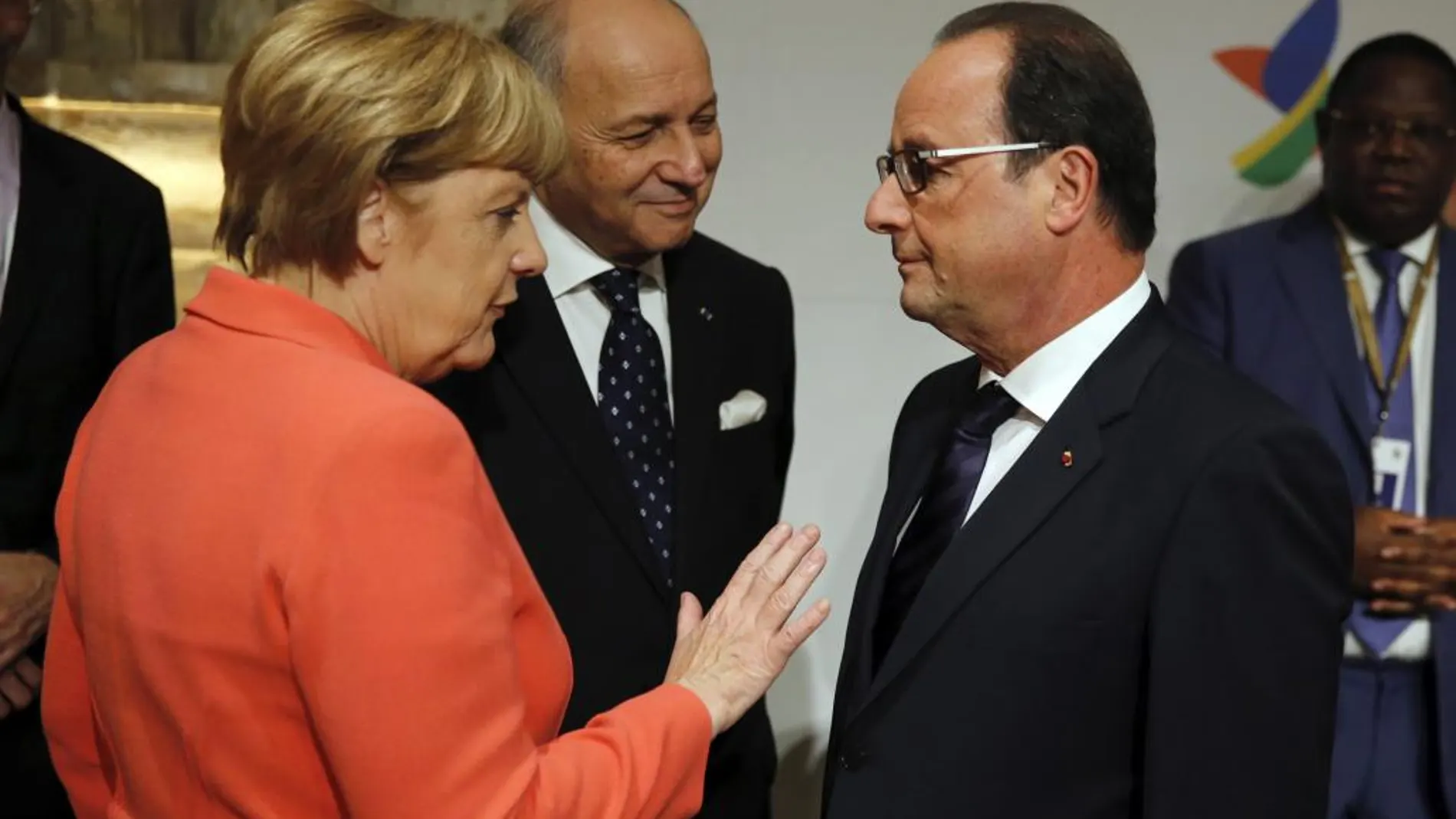 La canciller Ángela Merkel (i) conversa con el presidente francés François Hollande (d) junto con el ministro de Exteriores galo Laurent Fabius (c) al comienzo de la cumbre de La Valeta