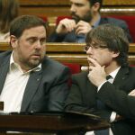 El presidente de la Generalitat, Carles Puigdemont (d), conversa con el vicepresidente Oriol Junqueras (i)