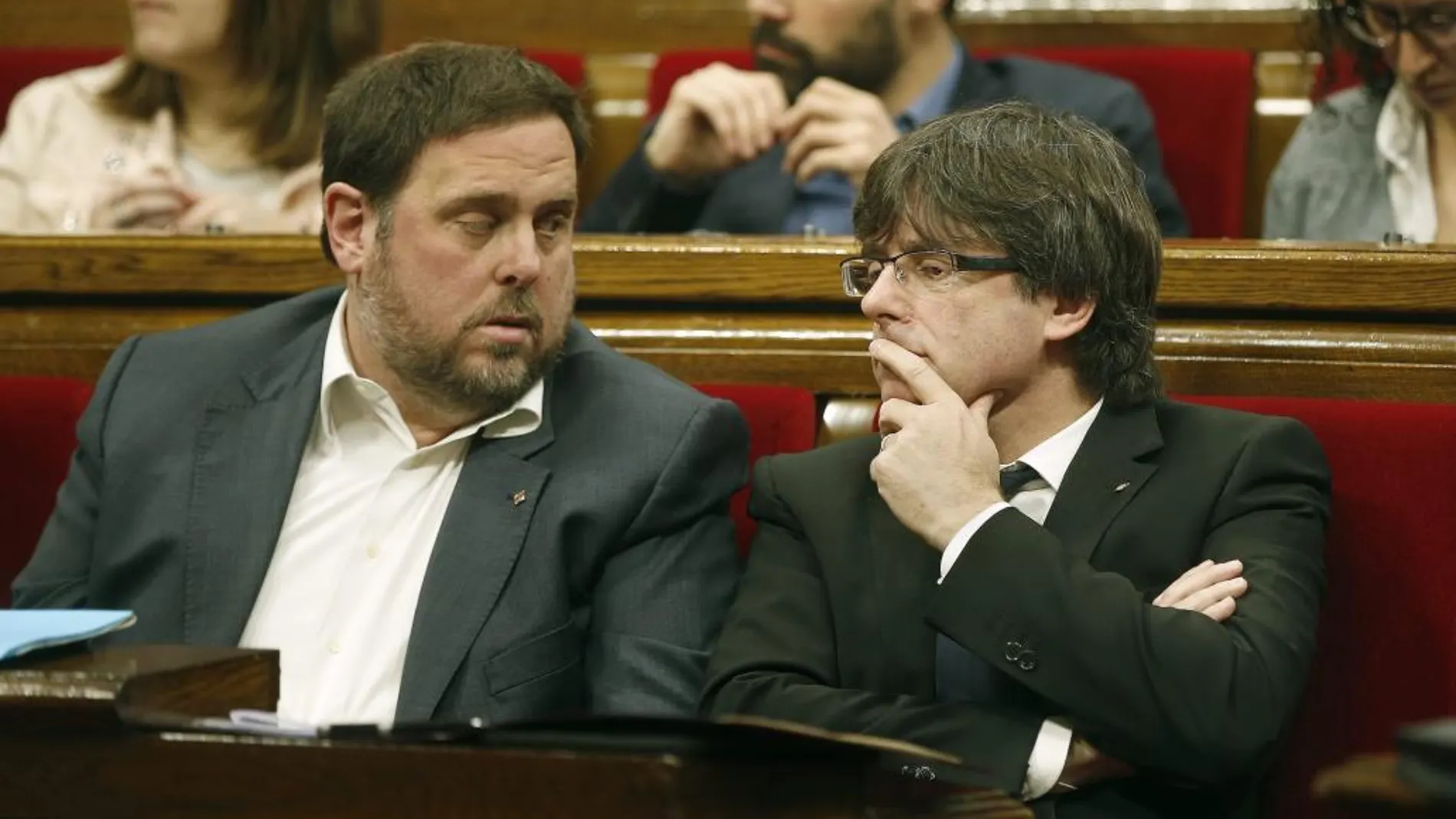 El presidente de la Generalitat, Carles Puigdemont (d), conversa con el vicepresidente Oriol Junqueras (i)