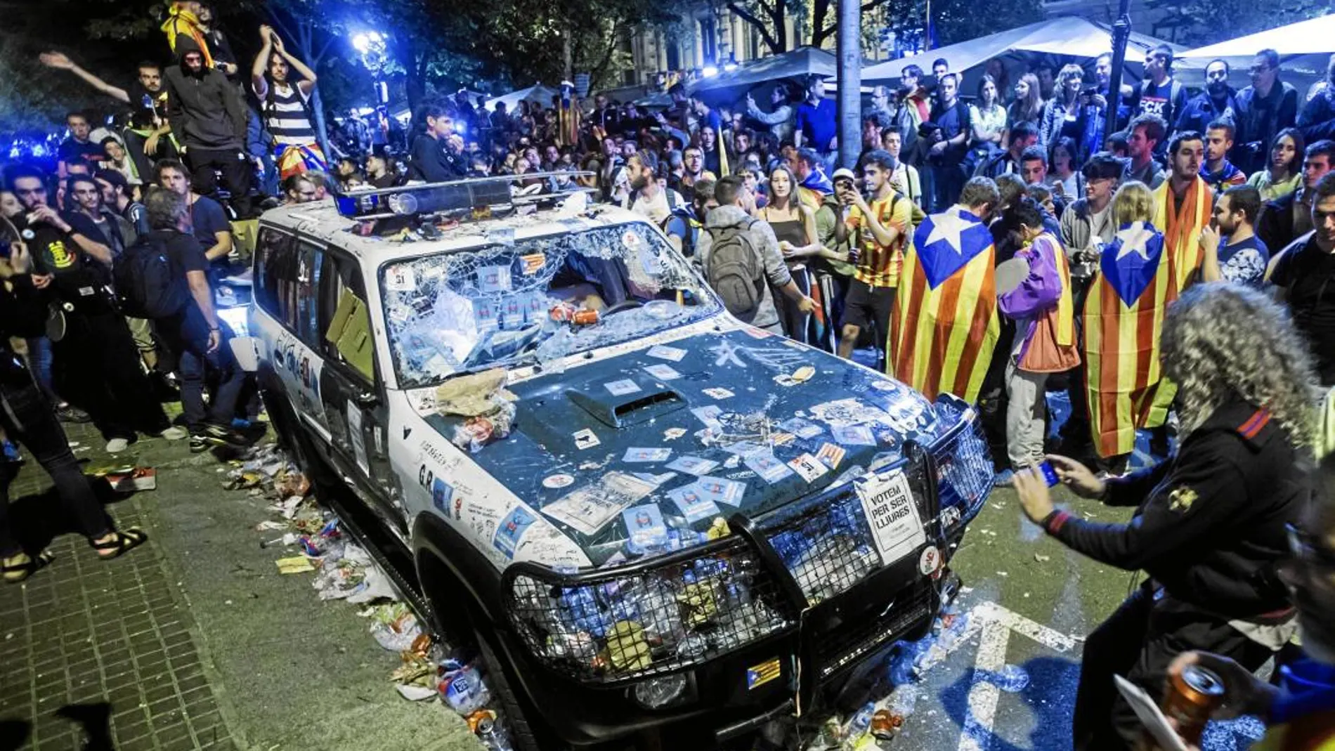 Imagen de los coches de la Guardia Civil destrozados tras la concentración del 20-S ante la conselleria de Economía. Foto: Efe