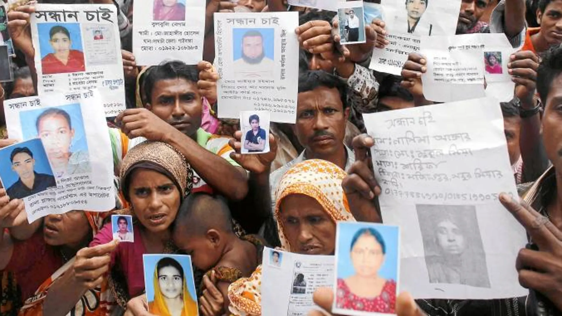 Familiares de los trabajadores del Rana Plaza muestran imágenes de sus parientes desaparecidos tras el derrumbamiento del inmueble en Dacca, Bangladesh