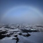 Un arco iris apareciendo en el horizonte en el Ártico