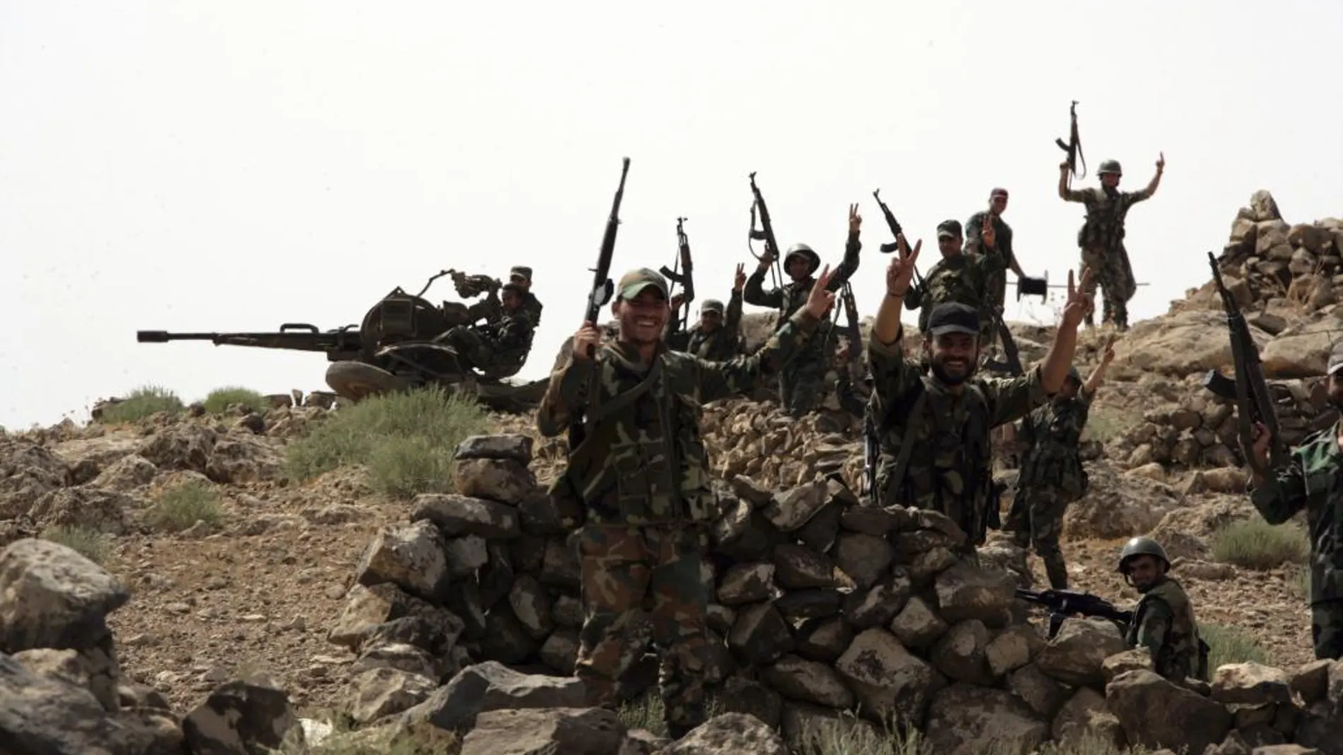 Soldados sirios hacen el signo de la victoria tras tomar el control de un territorio rebelde en la provincia sureñña siria de Al Sueida, hoy 12 de julio de 2017