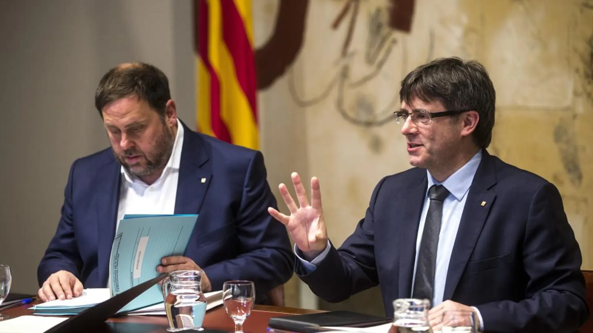 El presidente de la Generalitat, Carles Puigdemont (d), y su vicepresidente, Oriol Junqueras