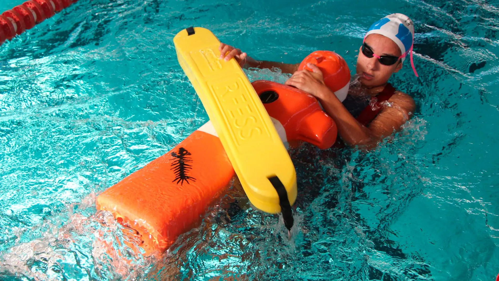 Deportista durante un ejercicio de socorrismo en piscina en el que remolca hasta la orilla a un maniquí estanco de unos 70 kilos de peso