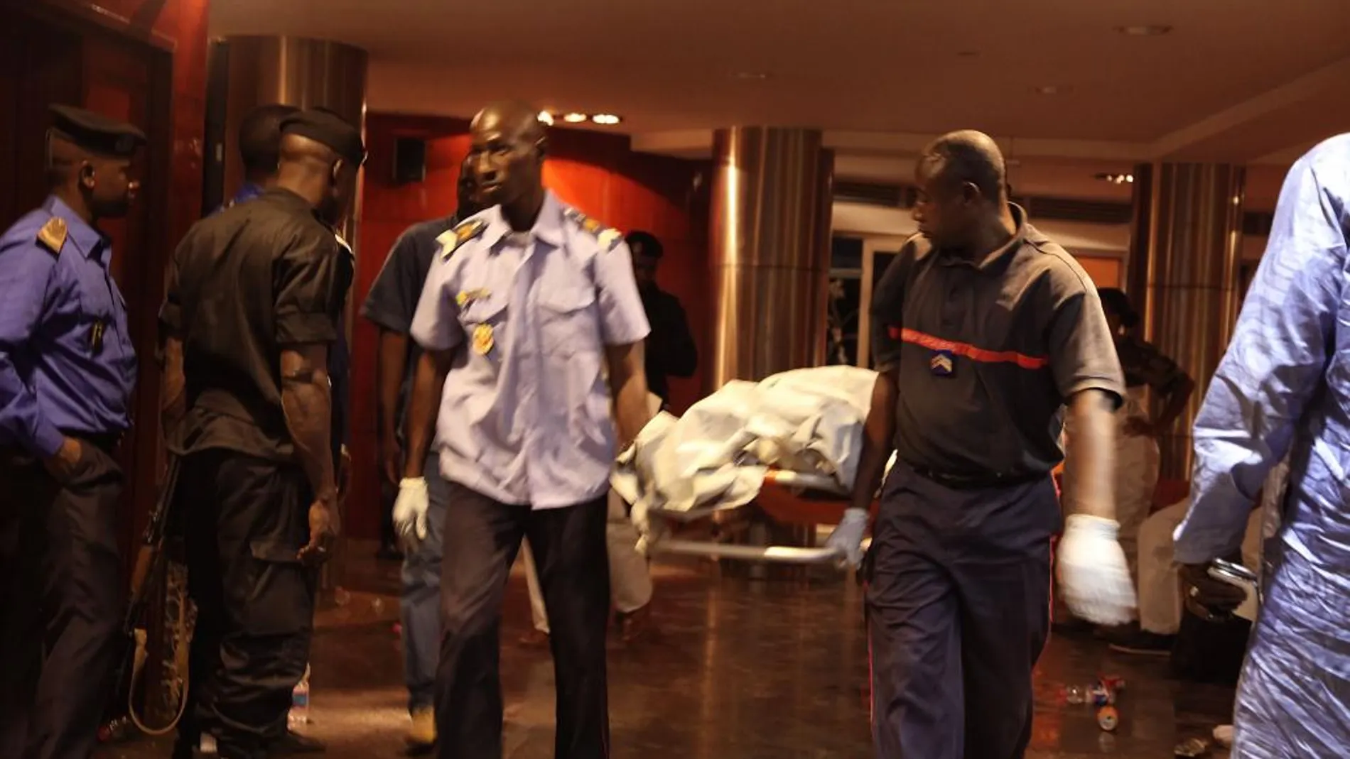 Personal de seguridad traslada el cadáver de una de las víctimas del ataque al hotel de Bamako