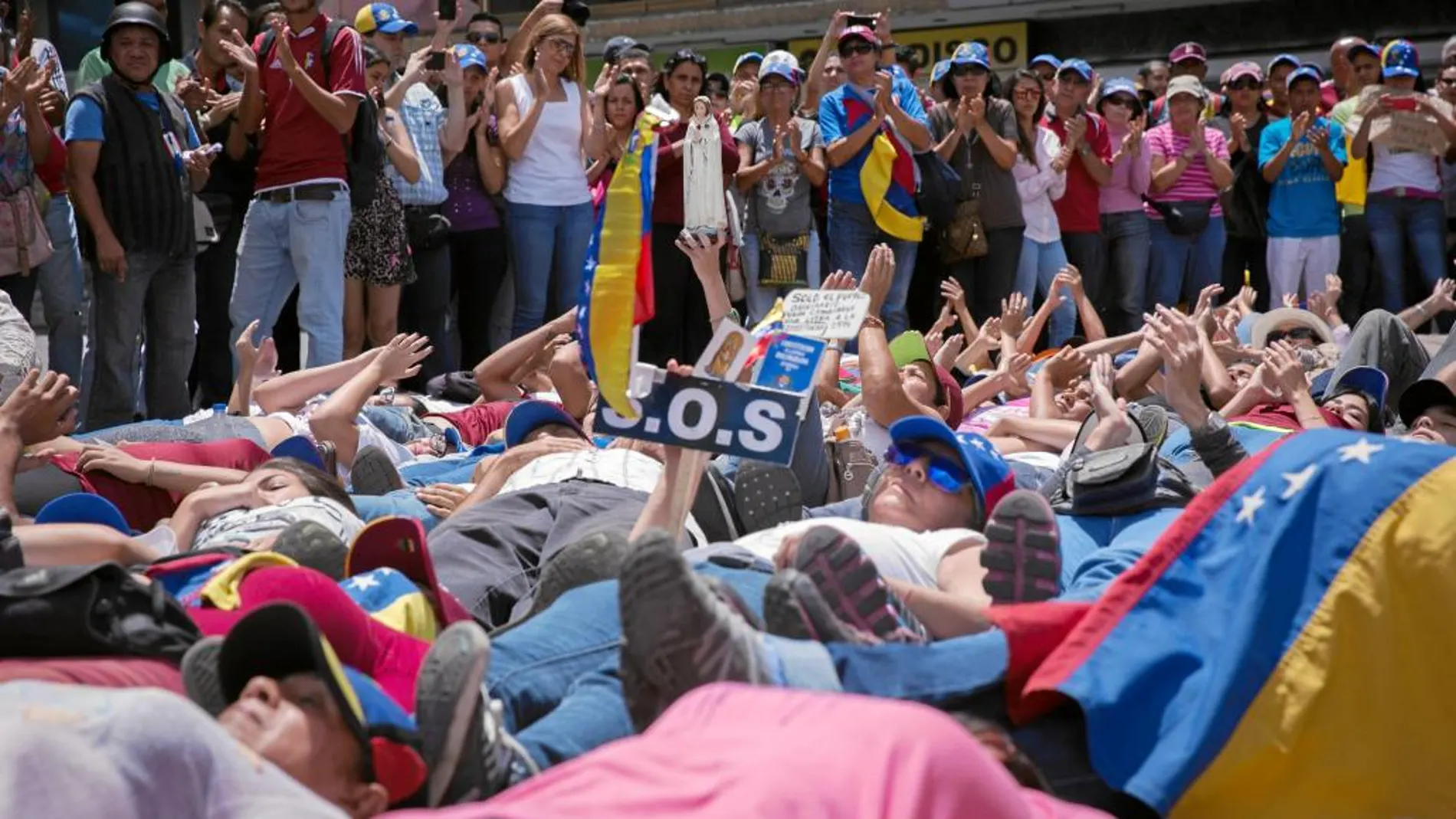 Opositores venezolanos participan en una protesta en Caracas por las víctimas de dos meses de manifestaciones
