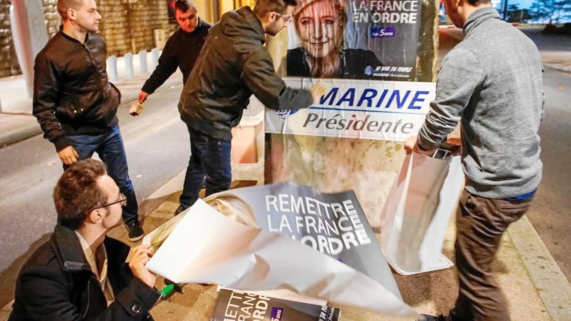 Seguidores frentistas pegan carteles de su líder a las puertas del congreso nacional en Lyon