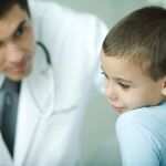Un médico examina el oído de un niño en la consulta