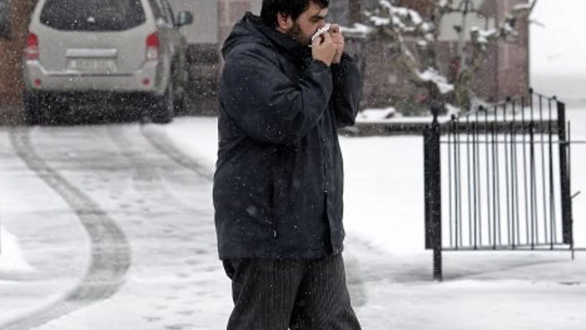 Un señor camina por la calle, afectado por la gripe, que durante este inicio de año está manteniendo una incidencia elevada
