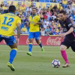 El defensa brasileño de Las Palmas Michel Macedo (i) disputa un balón con el delantero argentino Leo Messi (d).