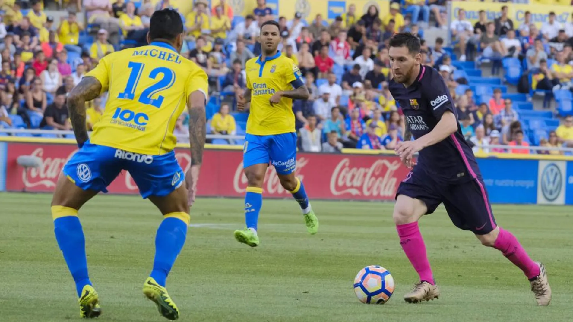El defensa brasileño de Las Palmas Michel Macedo (i) disputa un balón con el delantero argentino Leo Messi (d).