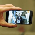El presidente Mauricio Macri, en la pantalla de un móvil en el momento de anunciar el ajuste fiscal