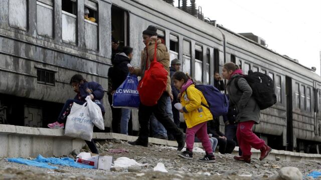 Refugiados se apresuran a subir a un tren que los llevará a Serbia desde el centro de tránsito para los refugiados, cerca de la ciudad de Gevgelija del sur de Macedonia