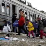 Refugiados se apresuran a subir a un tren que los llevará a Serbia desde el centro de tránsito para los refugiados, cerca de la ciudad de Gevgelija del sur de Macedonia