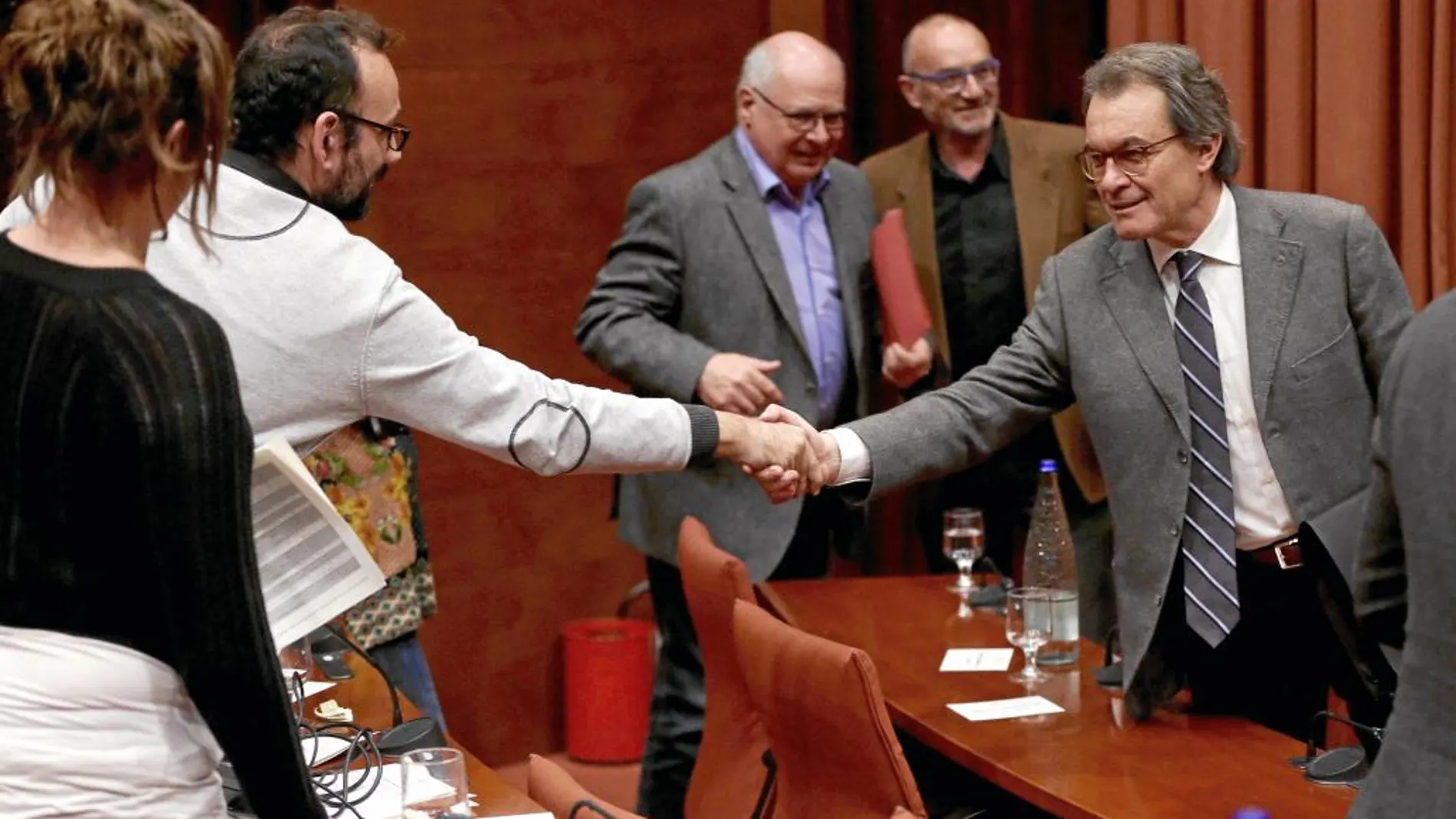 Artur Mas saludando al diputado de la CUP, Benet Salellas, al concluir a su comparecencia en el Parlament