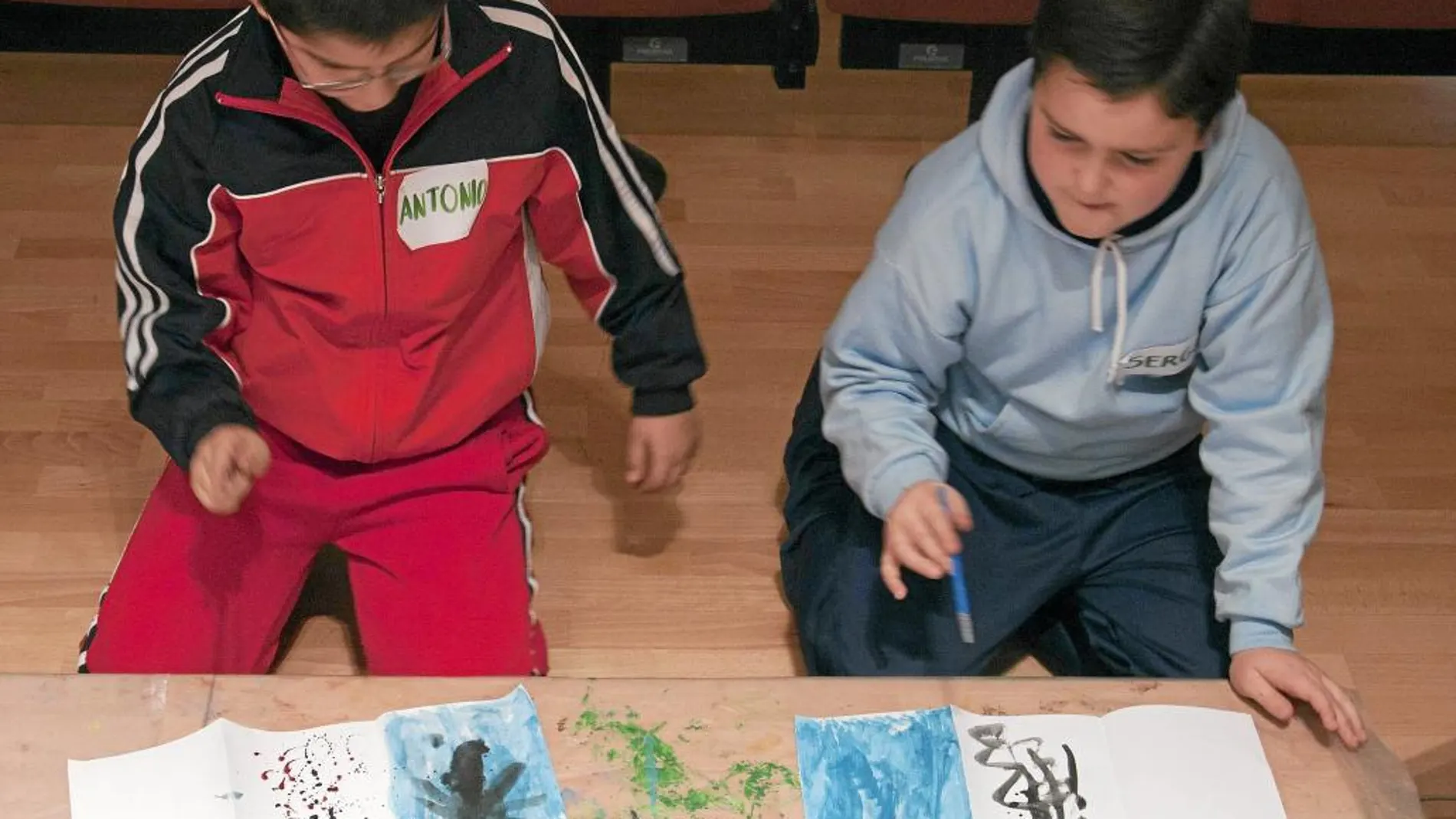 Dos niños participan en un taller de pintura