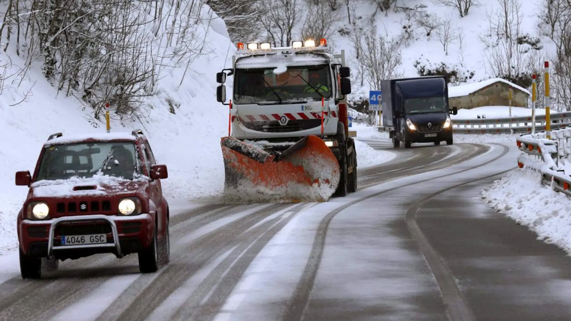 Una máquina quitanieves limpia la carretera de Pajares que se encuentra cubierta de nieve