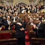 El presidente catalán en funciones, Artur Mas (de espaldas), saluda a Carles Puigdemont, poco antes de comenzar el pleno del Parlament.