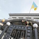 Un manifestante coloca una bandera ucraniana en la puerta de la embajada rusa en Kiev.