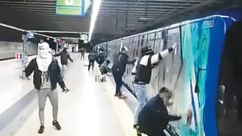 Momento en el que un grupo de encapuchados pintaron, el pasado día 31, un vagón en la estación de Casa de Campo