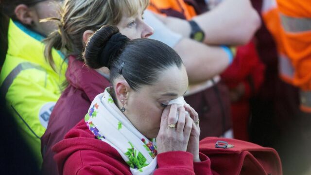 Miembros de los servicios de emergencia y trabajadores del aeropuerto asisten a un acto conmemorativo en Bruselas