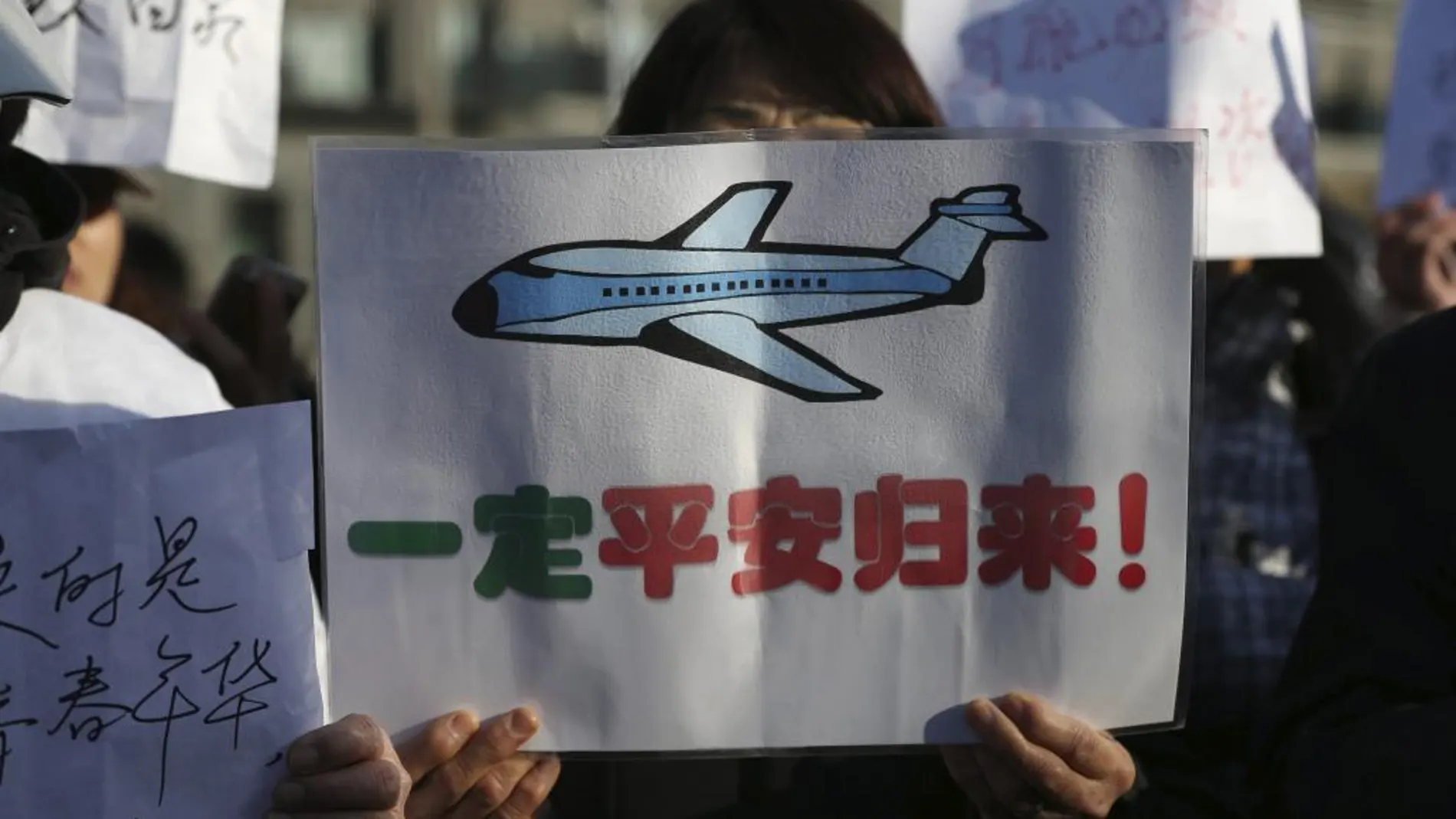 Familiares de los pasajeros del vuelo MH370 de Malaysian Airlines desaparecido protestan a las puertas de la embajada de Malasia en Pekín (China)