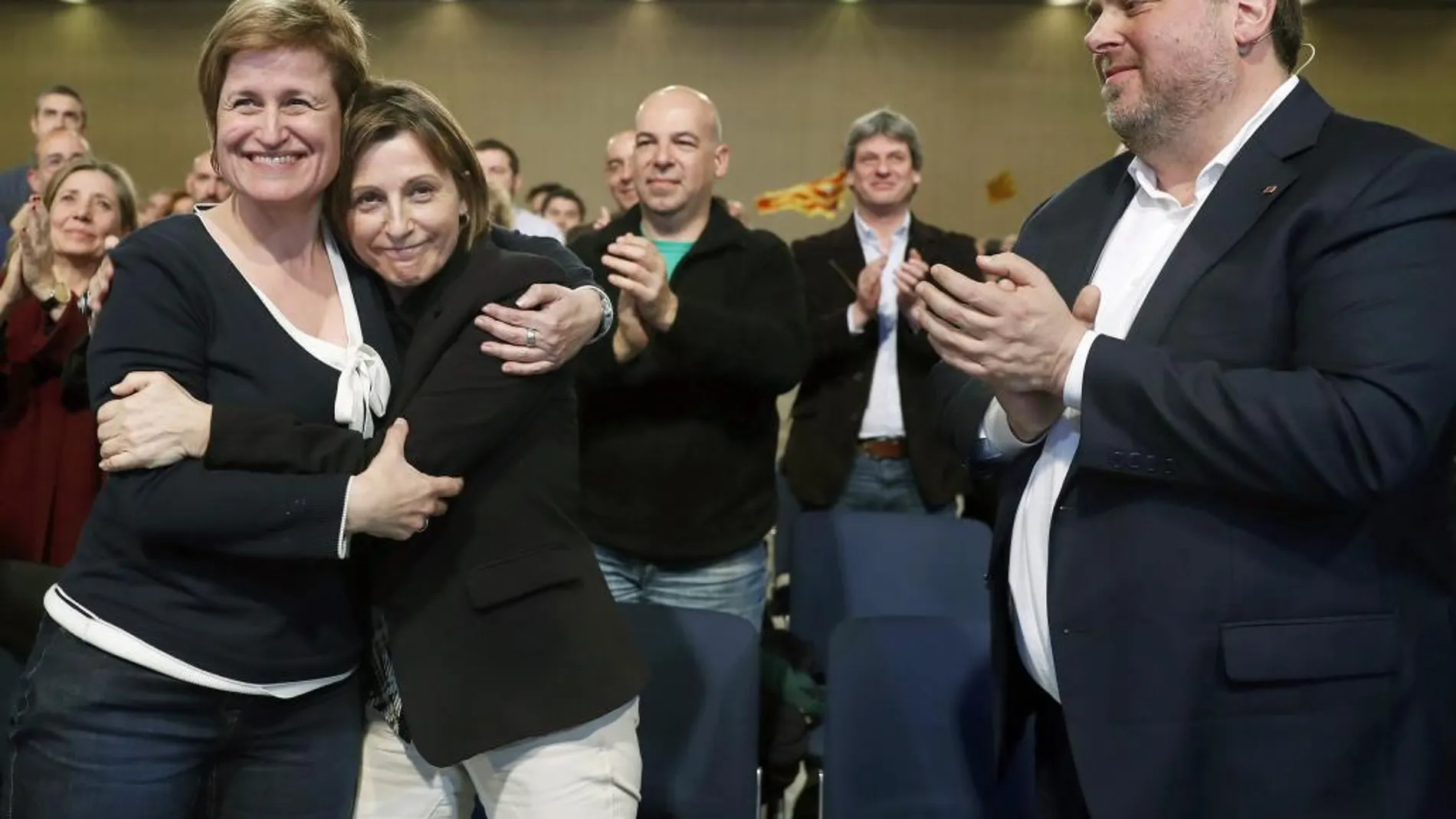 La presidenta del Parlament de Cataluña, Carme Forcadell, se abraza a la diputada Anna Simo, en presencia del líder republicano, Oriol Junqueras, durante un acto de ERC