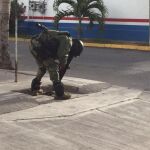 Un integrante de la Marina Armada de México apunta con su arma hacia adentro de una alcantarilla durante la detención de El Chapo.