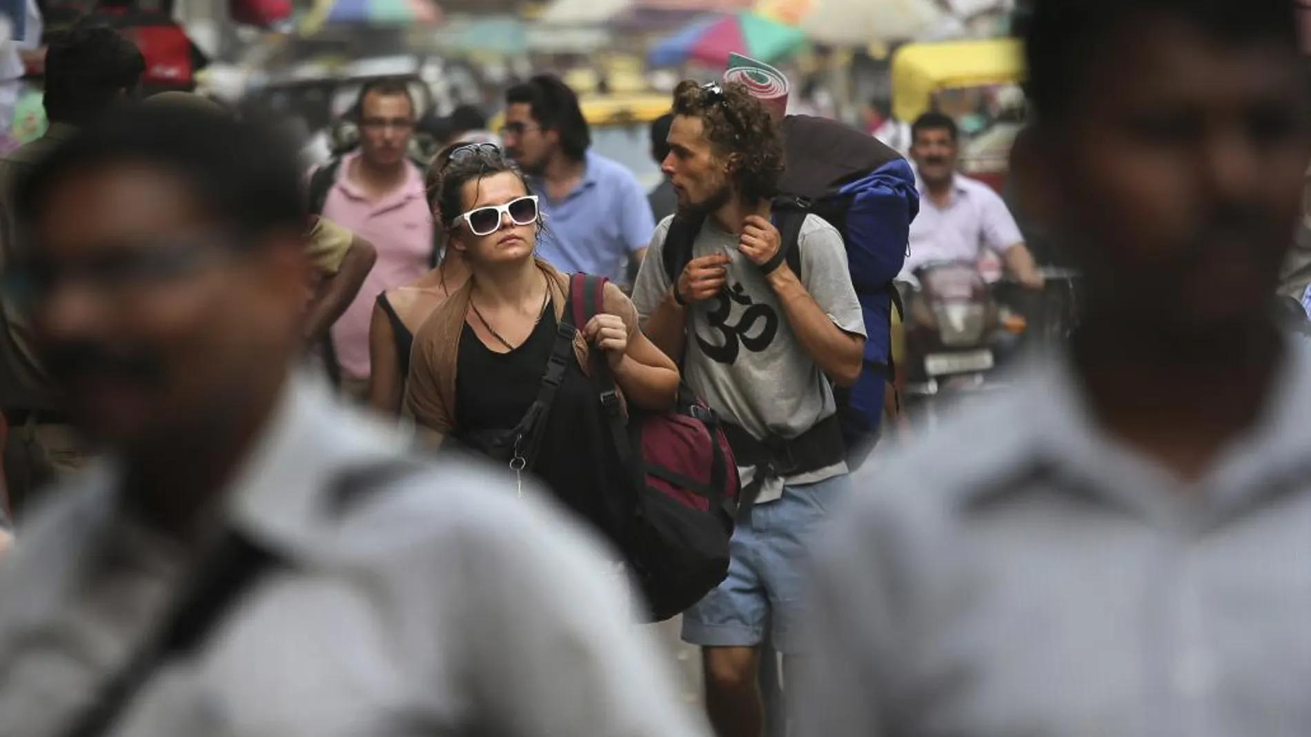 Turistas pasean por una calle de la India.