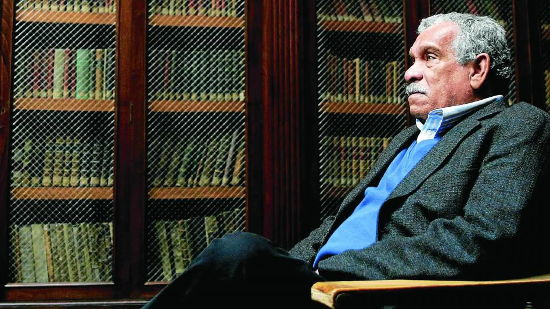 El poeta Derek Walcott, sentado en la biblioteca de la Universidad de Oviedo, en 2006