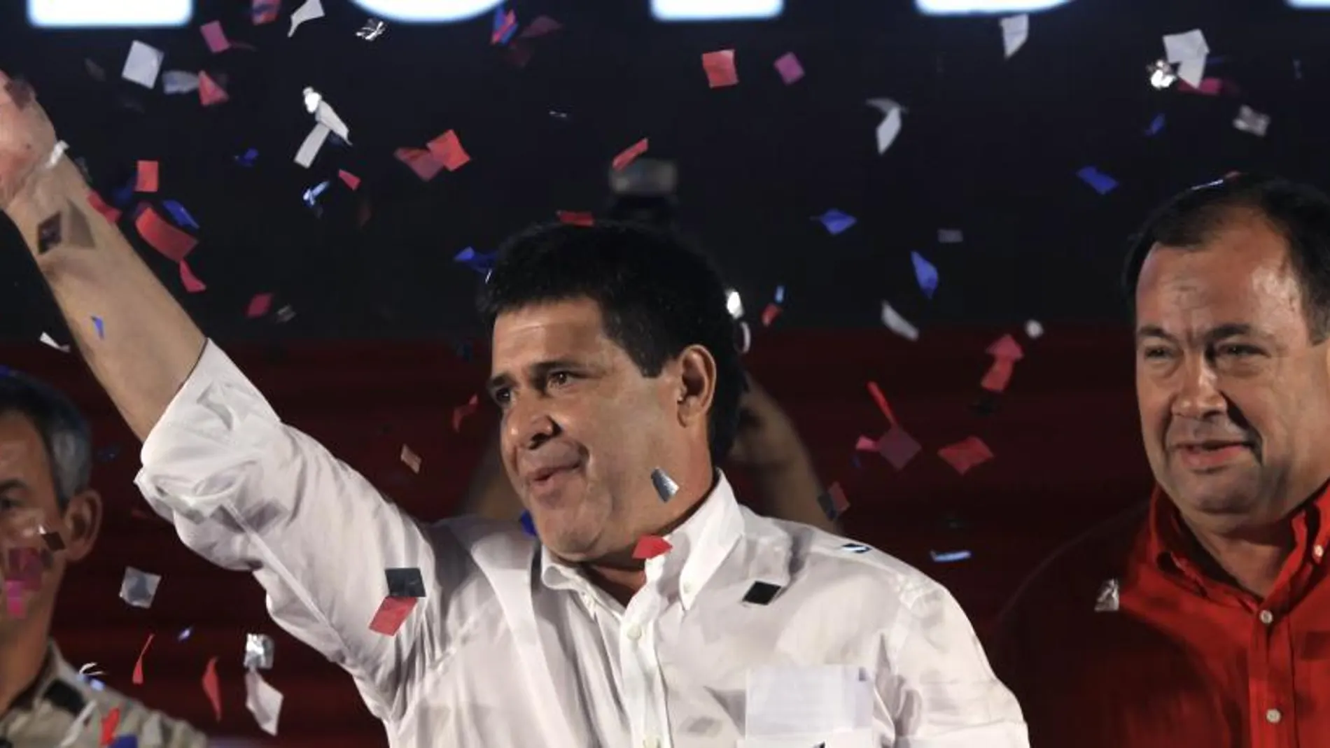 Colorado Party's presidential candidate Horacio Cartes, waves to supporters in Asuncion, Paraguay, Sunday, April 21, 2013. Cartes won a five-year term with 46 percent of the vote over 37 percent for Efrain Alegre of the Radical Liberal party, the Electoral Court announced after most votes were counted. Five other candidates trailed far behind. At right is Vice-President elect Juan Afara.(AP Photo/Jorge Saenz)