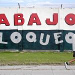 Un cubano camina por La Habana delante de un cartel que pide acabar con el embargo económico a la isla