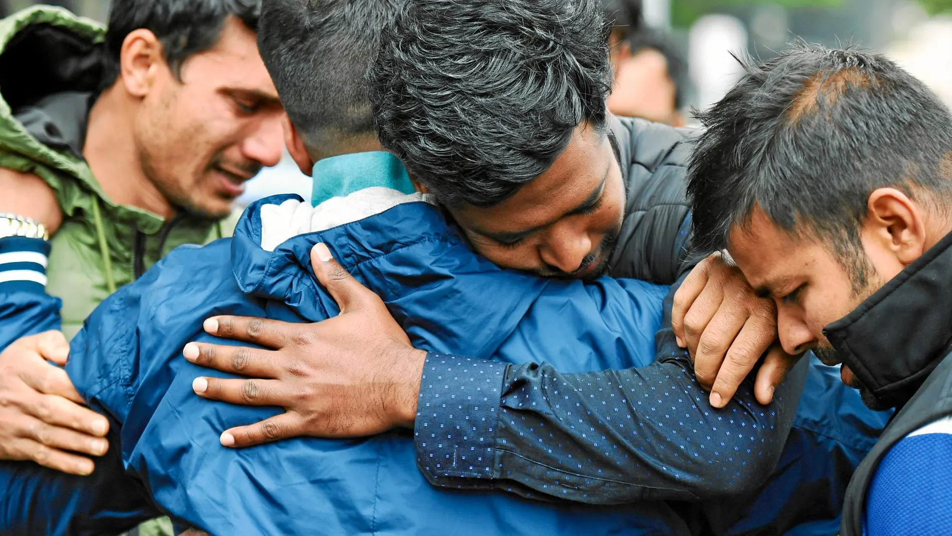 Familiares y amigos de una de las víctimas de la mezquita de Christchurch (Nueva Zelanda) se abrazan en un centro de acogida