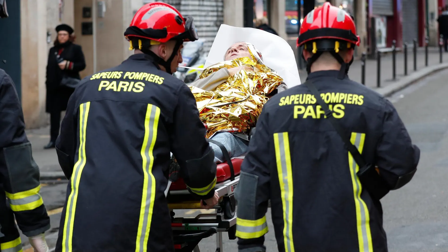 Los bomberos rescatando a una víctima de la explosión de una panadería en París/Ap