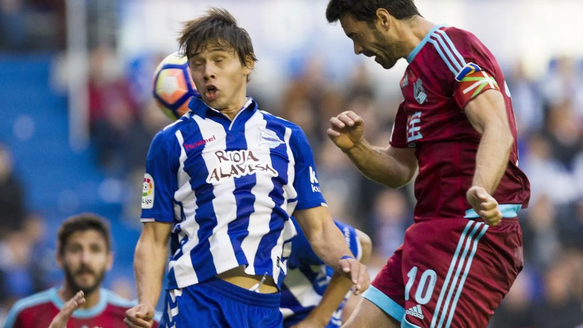 Óscar Romero (i) salta por el balón con el centrocampista de la Real Sociedad Xabi Prieto