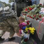 Un soldado deposita flores en memoria de Igor Debrin, joven policía de 24 años que perdió la vida ayer durante el enfrentamiento con manifestantes, frente al Parlamento en Kiev (Ucrania)