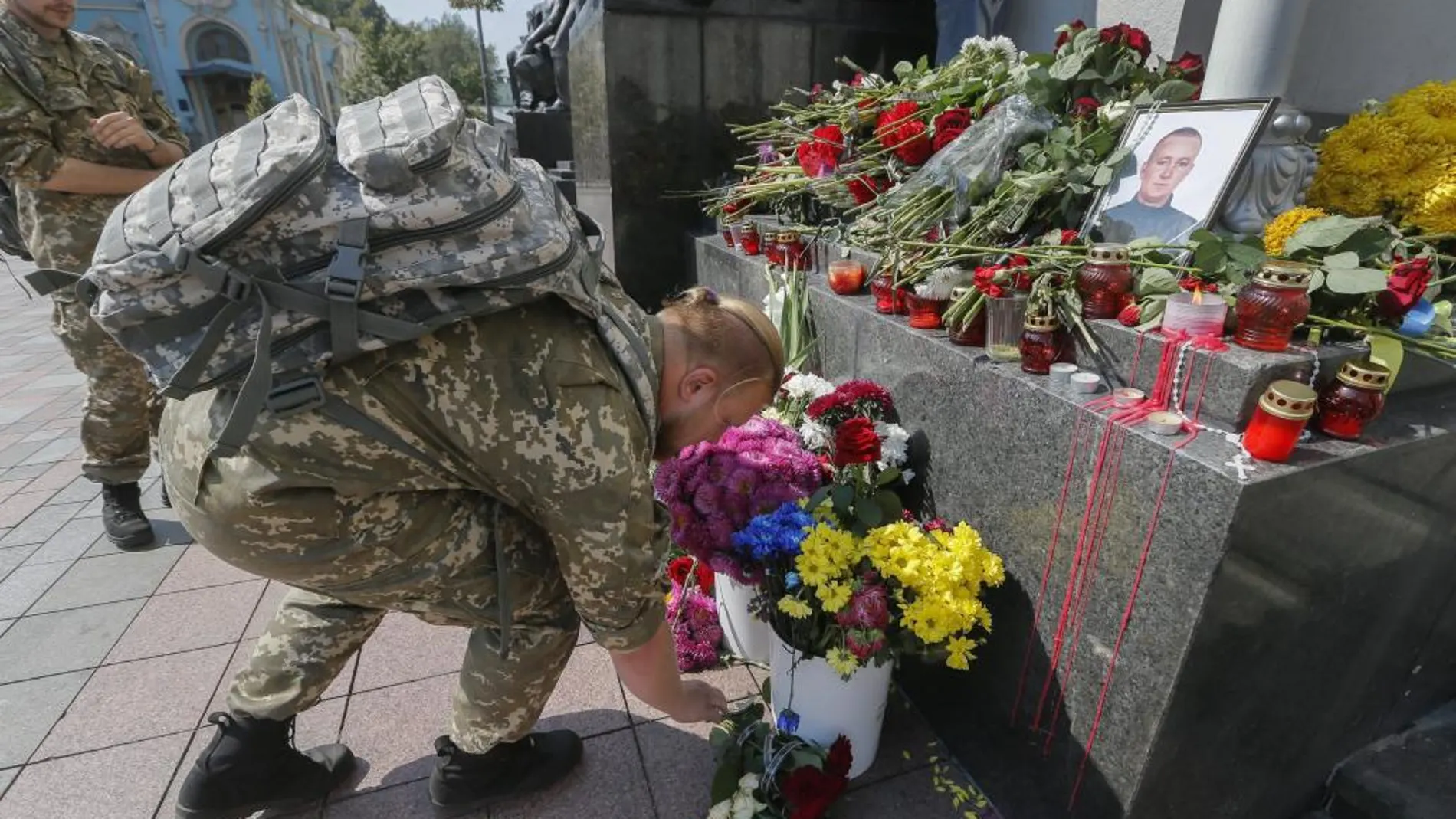 Un soldado deposita flores en memoria de Igor Debrin, joven policía de 24 años que perdió la vida ayer durante el enfrentamiento con manifestantes, frente al Parlamento en Kiev (Ucrania)