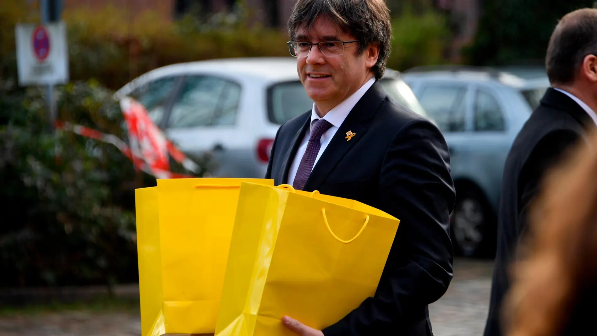 Puigdemont portando bolsas amarillas