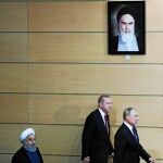 Bajo la sombra del ayatolá Jomeini. Hasan Rohani, Tayyip Erdogan y Vladimir Putin en la rueda de prensa conjunta que ofrecieron tras reunirse en Teherán para buscar una solución conjunta a la crisis siria.