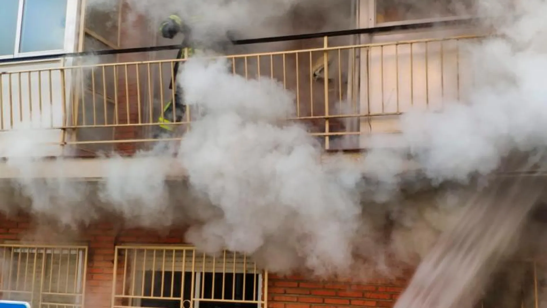 Los bomberos durante su intervención en el piso incendiado/Fotos y vídeo: Jesús Buitrago