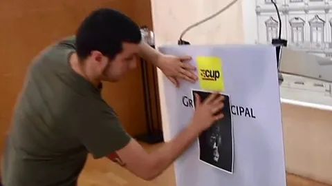 Edgar Fernández pega en el atril la imagen del Rey cabeza a bajo