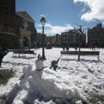 Varios niños juegan con la nieve hoy en una plaza de Prades (Tarragona)