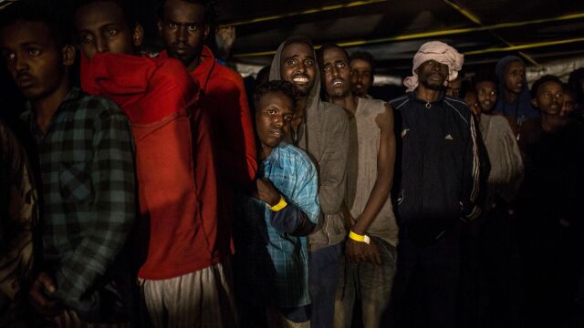 Varios inmigrantes permanecen en la cubierta del barco de Proactiva Open Arms tras ser rescatados del Mediterráneo