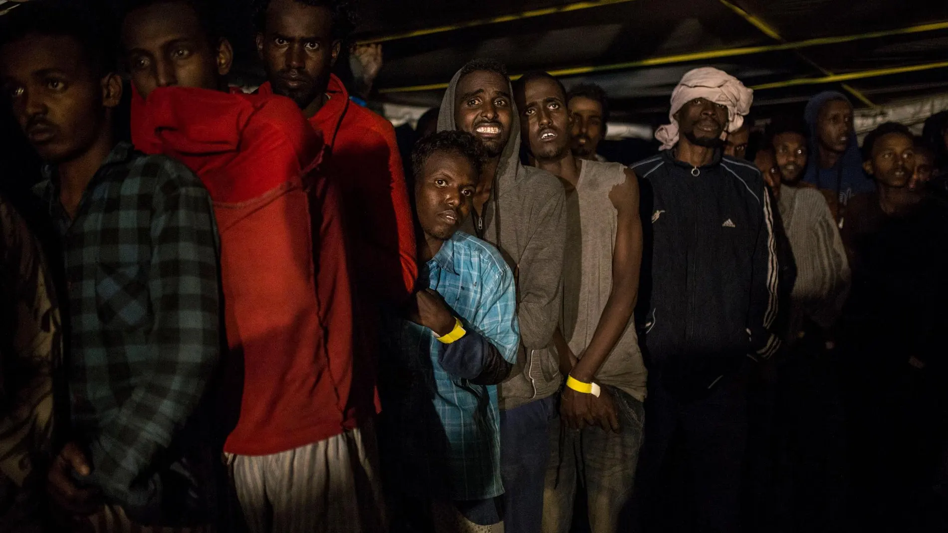 Varios inmigrantes permanecen en la cubierta del barco de Proactiva Open Arms tras ser rescatados del Mediterráneo
