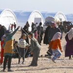 Un grupo de niños sirios juegan ayer junto a un campo improvisado en el norte del país junto al paso fronterizo de Bab al Salam